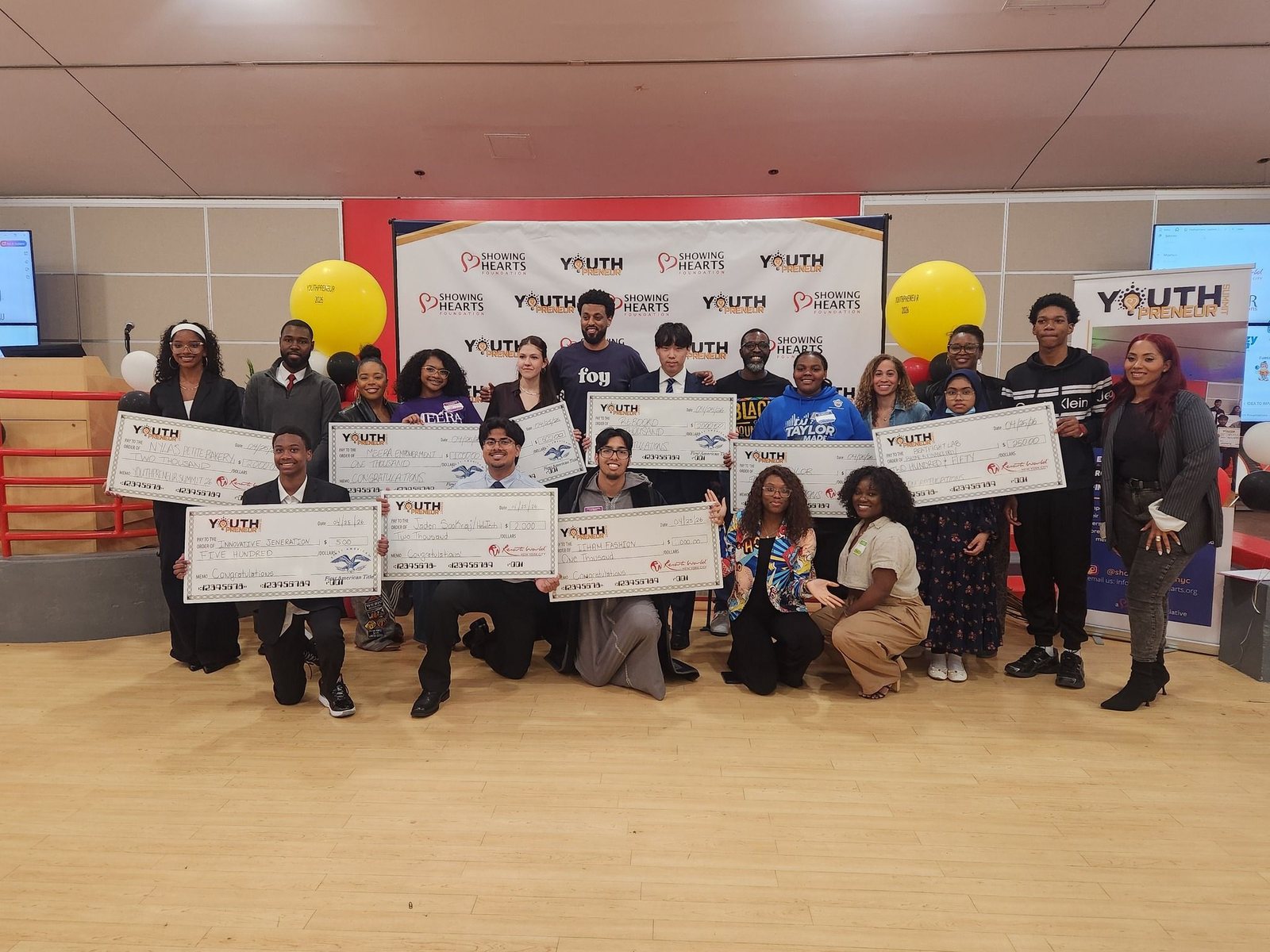 YouthPreneur Summit pitch competition winners holding oversized prize checks